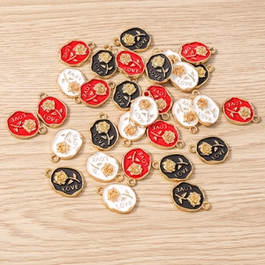 Detailed macro view of 10-piece enamel rose flower charms with LOVE engraving for jewelry making