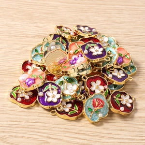 Detailansicht bunter Emaille-Blumenanhänger mit goldenem Metallrand und kleinen Perlen