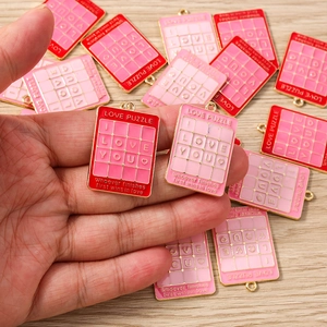 Detailansicht der roten und rosa Puzzle-Anhänger mit I LOVE YOU Gravur und Goldrand