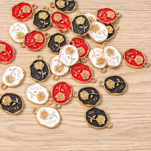 Detail of metal rose charms with LOVE engraving in red, black and white enamel finishes