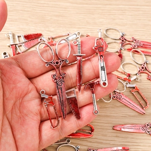 Macro shot of miniature bloody tool charms including saw and scissors for Halloween DIY
