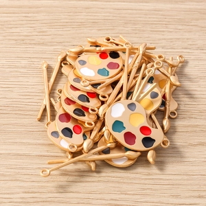 Détail de pendentifs palette d'artiste dorés avec émail coloré pour la création de bijoux DIY