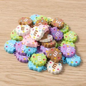 Gros plan de breloques biscuits en résine avec lettres M pour bijoux artisanaux
