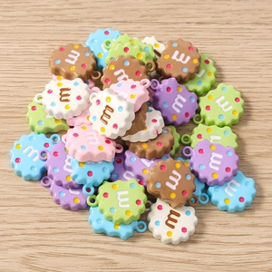 Détail de breloques biscuits en résine colorée avec lettre m pour bijoux DIY