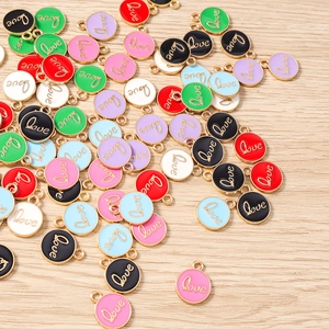 Macro shot of colorful round enamel Love charms with gold plated borders and lettering