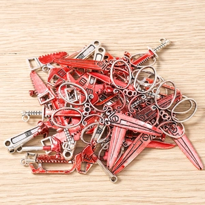 Detailed view of bloody silver metal tool charms including saws and scissors for jewelry
