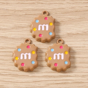 Vue détaillée de trois breloques biscuits en résine avec lettres m et bonbons colorés