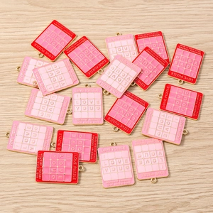 Detailansicht der rosa und roten Emaille-Puzzle-Anhänger für DIY-Schmuckherstellung