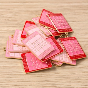 Nahaufnahme von roten und rosa Emaille-Anhängern I LOVE YOU für DIY-Schmuck mit Goldrand