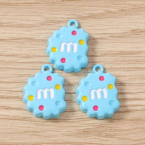 Détail du pendentif biscuit en résine bleu clair avec lettre m et points colorés pour DIY