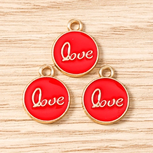 Macro view of three red enamel round Love charms with gold metal edges and hanging loops