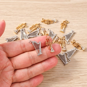 Détail de breloques trompettes en or et argent avec strass pour création de bijoux
