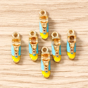 Set of 6 colorful alloy sneaker pendants for DIY jewelry making on light wood background