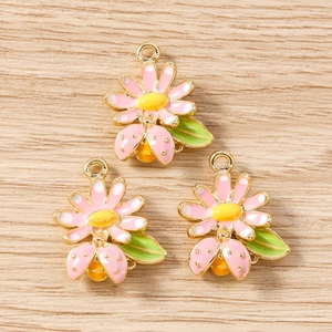 Détail de pendentifs fleurs et coccinelles en émail pour la fabrication de bijoux DIY