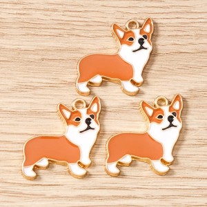 Macro shot of three orange and white enamel corgi dog charms for DIY jewelry making