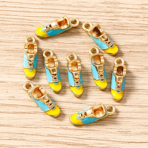 Flat lay of sneaker charms in blue and yellow enamel with gold metal base for DIY jewelry