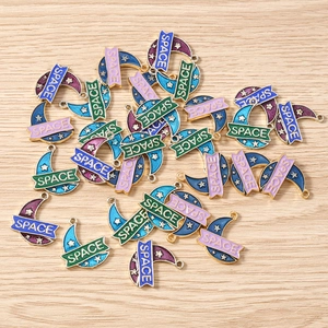 Detailed macro of enamel moon charms with sparkling sequins and space engraving