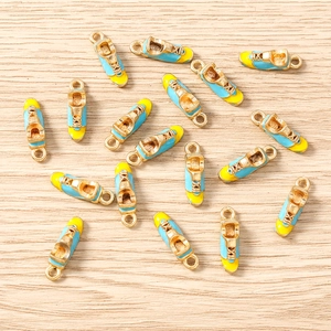 Macro detail of alloy sneaker charms with blue yellow enamel and golden soles for DIY jewelry