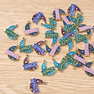 Detailed macro view of colorful enamel moon pendants with starry space pattern for DIY jewelry
