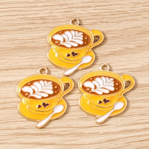 Dettaglio dei ciondoli a forma di tazza di caffè per gioielli con latte art e bordi dorati