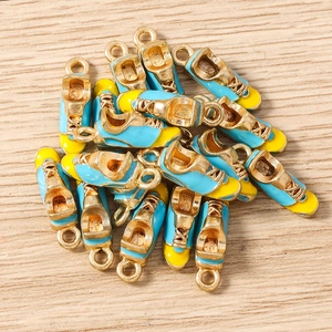 Detail of blue and yellow sneaker pendants for DIY jewelry making on wood background