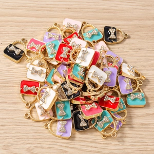 Macro detail of colorful enamel handbag charms with crystal bows for DIY jewelry making
