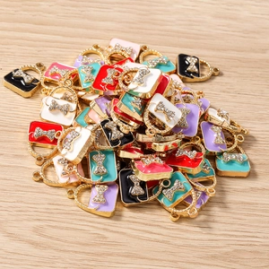 Macro detail of colorful handbag charms with rhinestones on light wood background