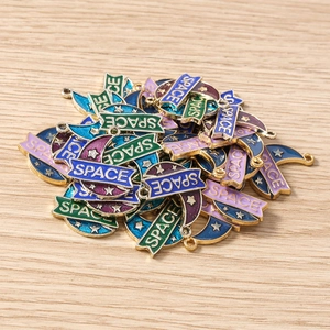 Detailed pile of colorful space-themed moon alloy pendants for DIY jewelry crafting
