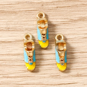 Detailed view of light blue and yellow enamel sneaker charms for DIY jewelry making