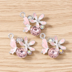 Détails macro de breloques fleurs et papillons avec cristaux et émail pour bijoux DIY