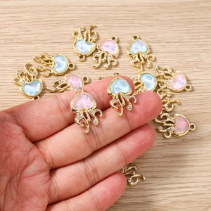 Détail de breloques méduse avec résine en cœur et tentacules dorés pour bijoux DIY