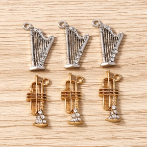 Détails macro de pendentifs instruments de musique dorés et argentés avec strass