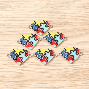 Detail view of heart-shaped puzzle charms with multi-color enamel for DIY jewelry