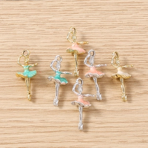 Close-up of ballet girl alloy pendants in pastel colors on natural wood surface