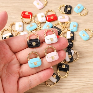 Détail de mini breloques sac à main colorées avec anses dorées pour création de bijoux