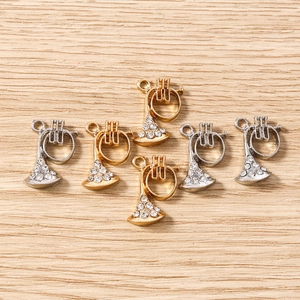 Vue détaillée de breloques trompettes or et argent avec strass pour bijoux DIY
