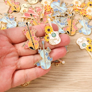 Detailed macro of enamel musical instrument charms with floral patterns and gold edges