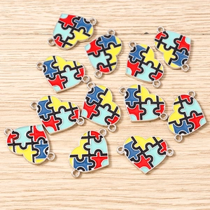 Close-up of enamel puzzle piece heart pendants for autism awareness jewelry DIY