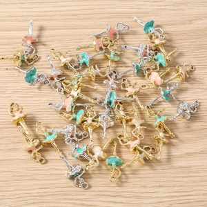 Detail of ballet dancer alloy pendants with colorful enamel skirts on wooden background