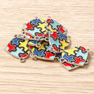 Detailed close-up of colorful enamel puzzle heart charms with silver double loops for DIY