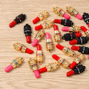 Macro-detail van lippenstiftvormige bedeltjes met kleurrijke strass-steentjes en goud