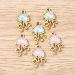 Vue détaillée de pendentifs méduse en résine irisée avec strass sur bois