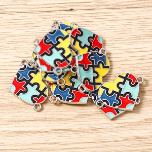 Close-up of four-color puzzle heart pendants with alloy enamel finish for DIY jewelry