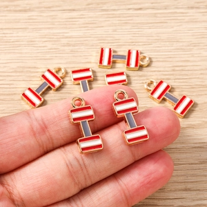 Vista de detalles de dijes de pesas con esmalte rojo y blanco para creación de joyas DIY