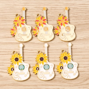 Detail of sunflower guitar charms with enamel finish for DIY jewelry making accessories