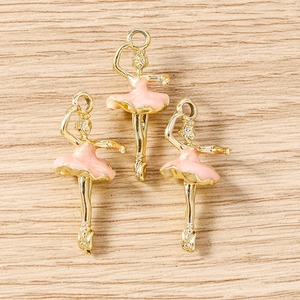 Detailed view of pink enamel ballerina charms with gold metal base for DIY jewelry