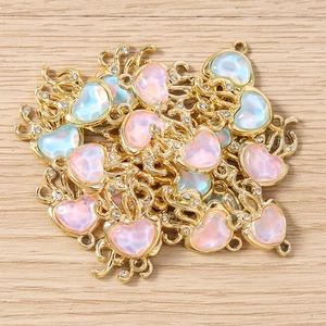 Vue détaillée des breloques cœur avec opale et cadre doré pour la création de bijoux DIY