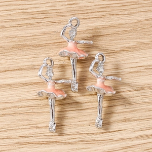 Macro detail of ballerina pendants with pink enamel skirts and silver alloy hooks