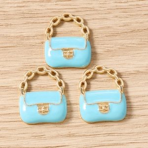 Détail macro de pendentifs sacs à main en émail bleu clair avec chaîne dorée pour bijoux DIY