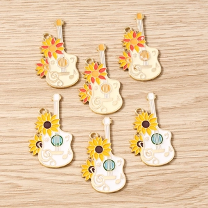 Detailed macro view of enamel guitar charms with sunflower patterns for DIY jewelry